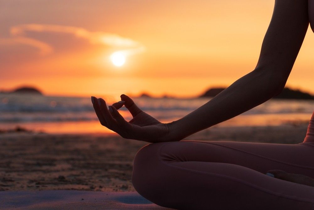 Pozitie de yoga pe plaja